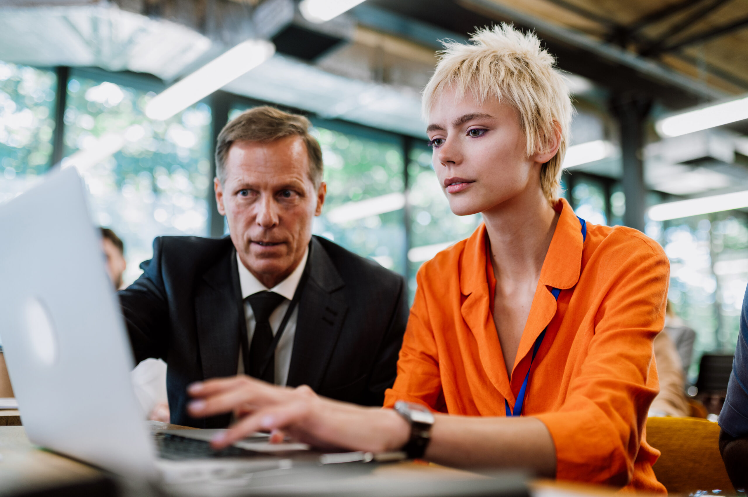 portrait-young-woman-using-laptop-office-scaled.jpg Two colleagues working together on laptop